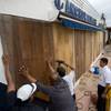 Photo: Workers board over a store front Monday Sept. 5, 2 Photo: Workers board over a store front Monday Sept. 5, 2