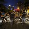 Photo: Demonstrators protest next to a police officer aft Photo: Demonstrators protest next to a police officer aft