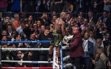 Super welterweight Floyd Mayweather Jr. celebrates is win over Conor McGregor standing on the ropes above the crowd at the T-Mobile Arena on Saturday, August 26, 2017.