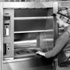 Photo: In this 1970s photo provided by NCR, a woman uses Photo: In this 1970s photo provided by NCR, a woman uses