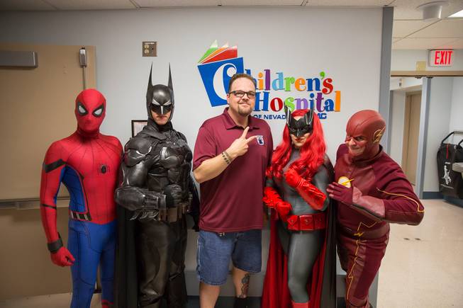 Critical Care Comics' Michael Mutzhause, as Spiderman, Tyler Moir, as Batman, Jason Golden, founder and president of Critical Care Comics, Lexi Kreuz, as Batwoman, and Chase Addison, as The Flash, pose for a photo at UMC's Children's Hospital as they deliver comic books and toys to kids, Saturday, Aug. 18, 2018.