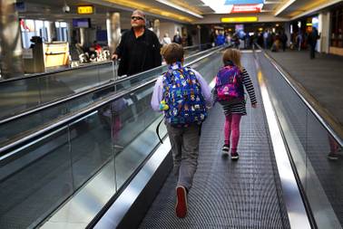 Children run on a moving walkway on a concourse at Baltimore-Washington International Thurgood Marshall Airport, Tuesday, Nov. 20, 2018, in Linthicum, Md. Favorable weather is helping get the Thanksgiving travel rush off to a smooth start. By midday Tuesday, just a few dozen flights had been canceled around the U.S. That's fewer cancelations than many regular travel days.