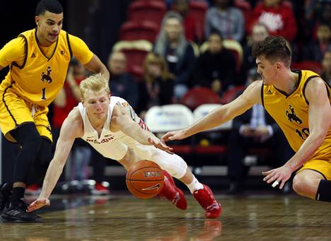 UNLV Rebels guard Trey Woodbury (22) and Wyoming Cowboys forward Hunter Thompson, right, (10) fight for a loose ball during a game at the Thomas & Mack Center Saturday, Jan. 5, 2019. Wyoming Cowboys guard Justin James (1) looks on at left.