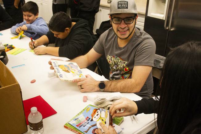 Volunteer Aaron Ameen helps clean donated books during a tour by Carlos Santana and his Milagro Foundation staff at the Spread the Word Nevada offices and warehouse in Henderson, NV, Thursday, Jan. 17, 2019. The Milagro Foundation made a donation to Spread the Word, which will provide about 15,000 books to 57 schools across Southern Nevada.