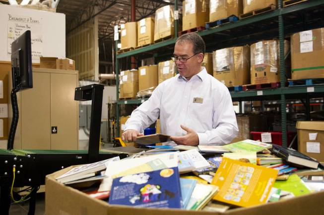 Director of Operation at Spread the Word Nevada David Ortlipp demos the book sorting machine during a tour by Carlos Santana and his Milagro Foundation staff at the Spread the Word Nevada offices and warehouse in Henderson, NV, Thursday, Jan. 17, 2019. The Milagro Foundation made a donation to Spread the Word, which will provide about 15,000 books to 57 schools across Southern Nevada.