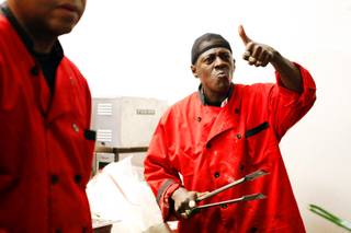 Flavor Flav prepares chicken during the grand opening of Flavor Flav's House of Flavor in Las Vegas on Thursday, March 15, 2012.