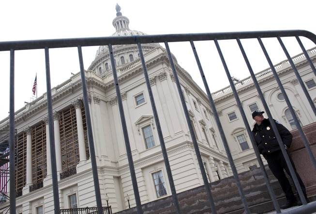 A security fence and Capitol Police Officer guard a staircase at the U.S. Capitol in preparation of President Barack Obama's Inauguration at The Joint Task Force, National Capital Region, Department of Defense dress rehearsal for military participation in the 57th Presidential Inaugural ceremonies in Washington, Sunday, Jan. 13, 2013.